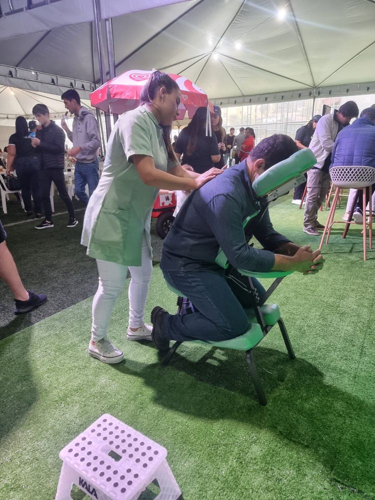 Atendimento de quick massage em tenda, em ação corporativa a céu aberto