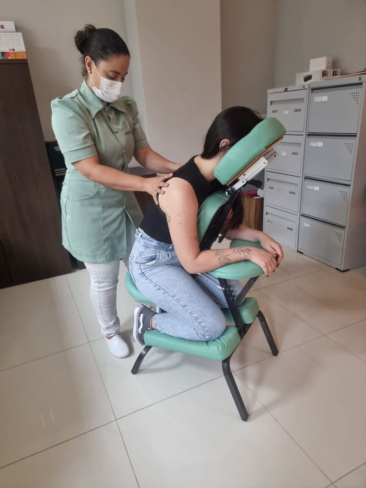 Profissional aliviando pescoço e ombros na cadeira de massagem